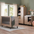 Baby cot bed with distressed oak frame and dark vertical slats