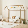Oak toddler floor bed with house frame, low guard rails, and dotted bedding