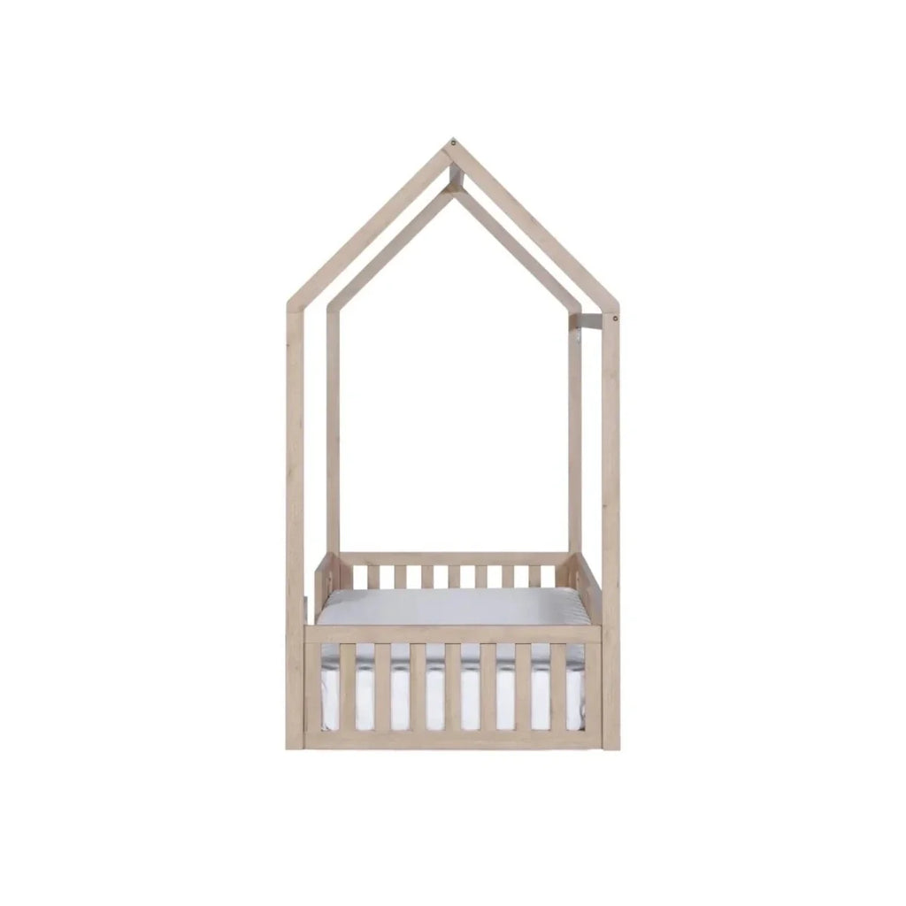Oak house-shaped toddler floor bed frame with low guard rail and white mattress