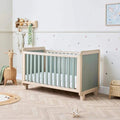 Wooden cot bed with sage side panels and vertical slats, golden oak frame