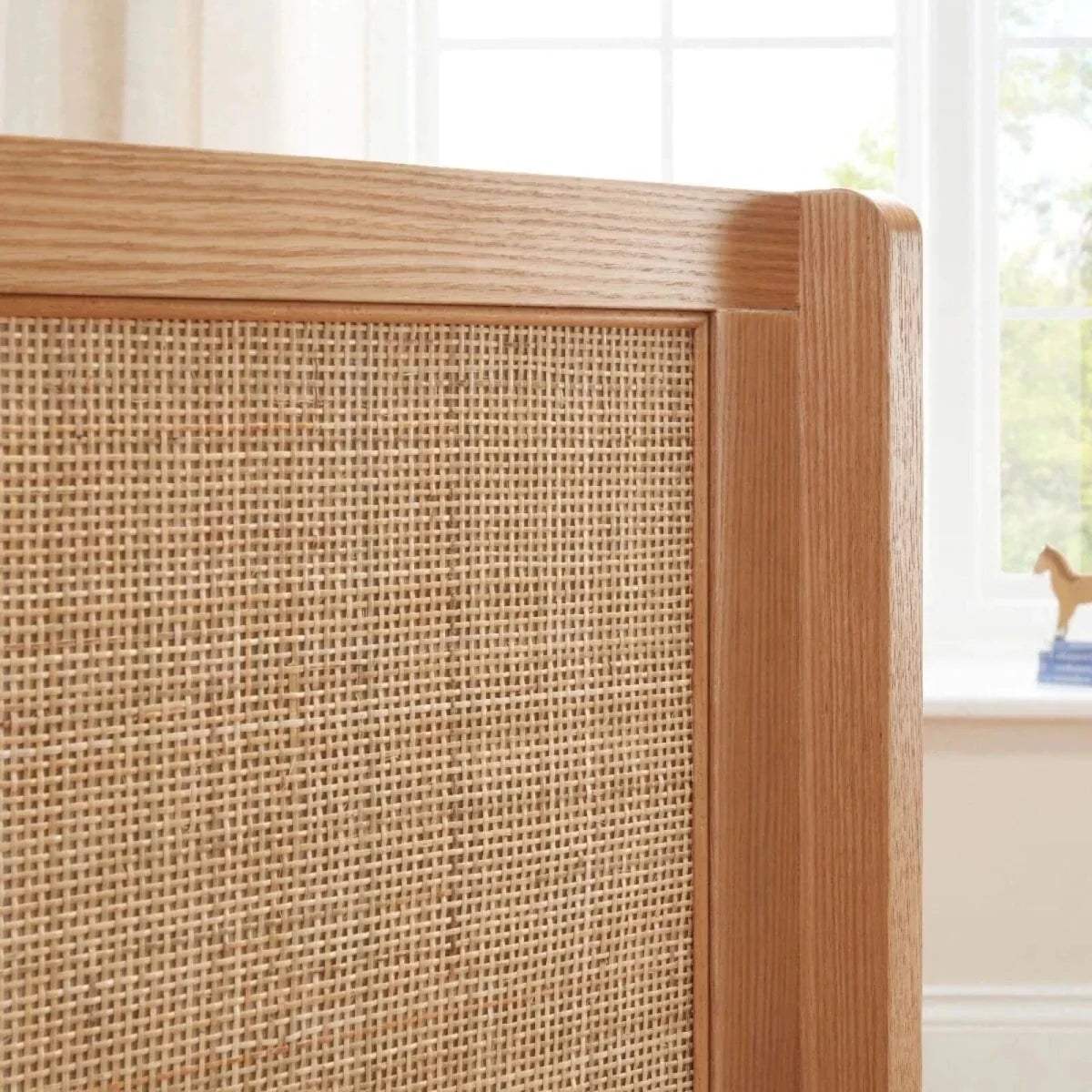 Woven fabric side panel framed in light oak on a cot bed