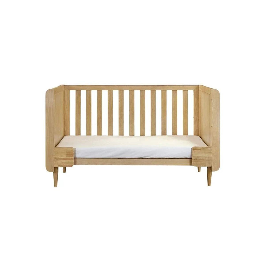 Light oak cot bed with vertical slatted headboard and matching side rails