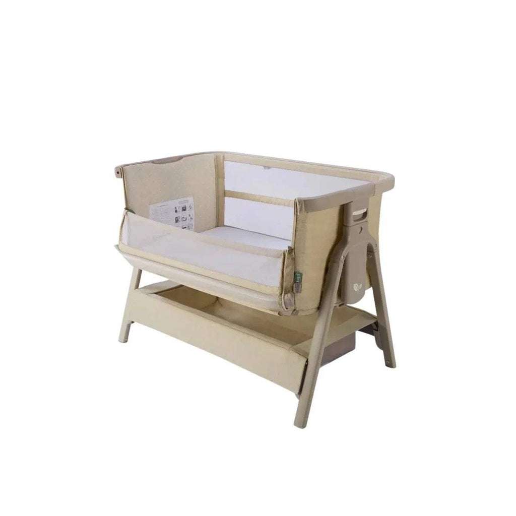 Sand bedside crib, angled view with mesh side panels and open base