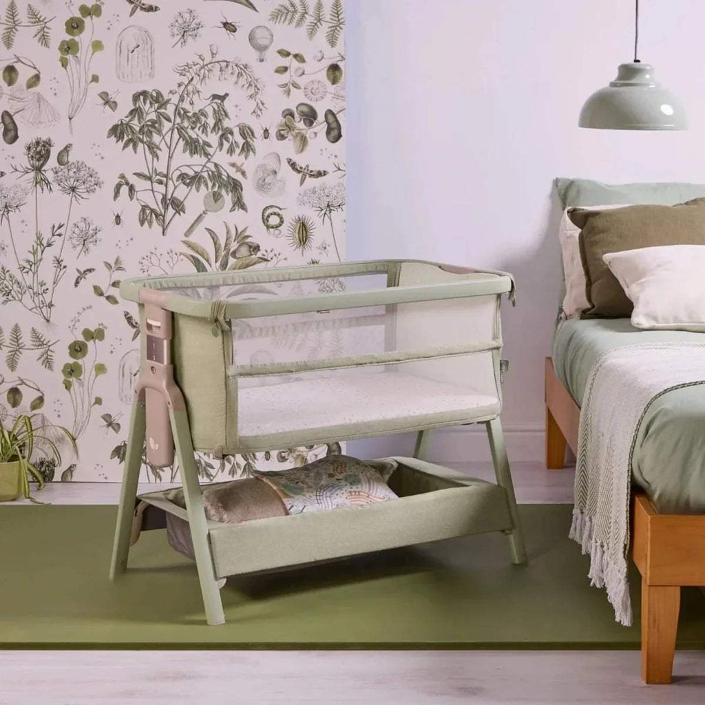 Eucalyptus green bedside crib with open front panel and padded mattress area