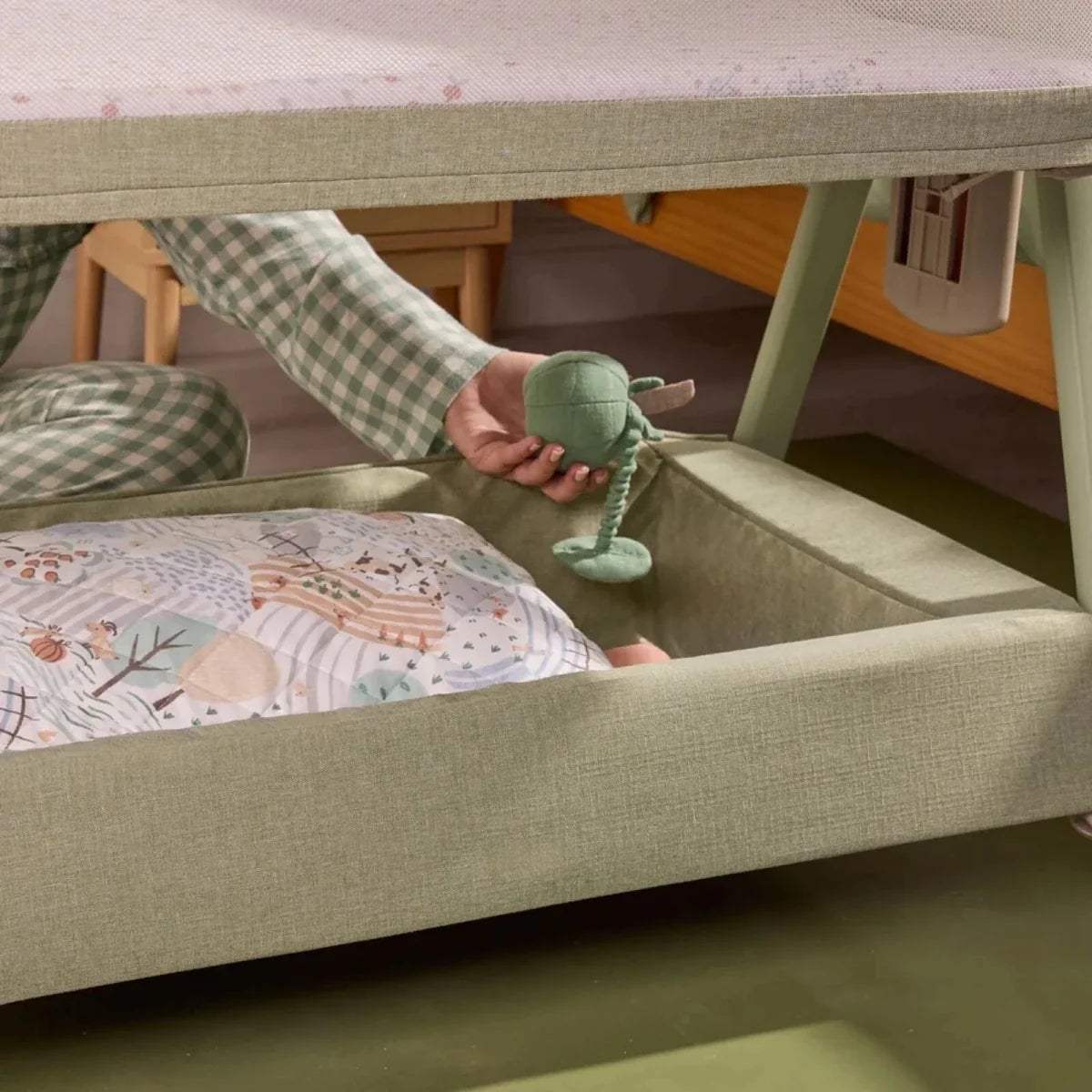 Eucalyptus green bedside crib with open side and lower access area for reaching in