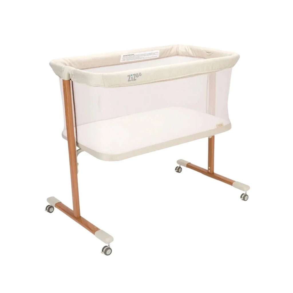 Ecru crib with walnut legs, mesh sides, padded mattress base, and caster wheels