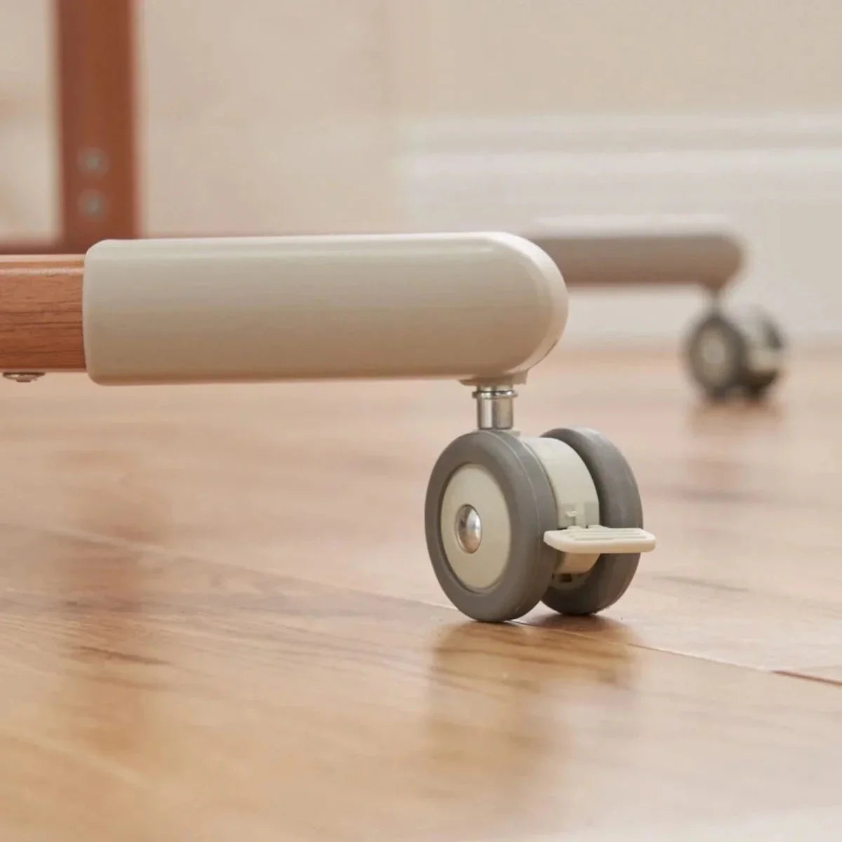 Walnut crib base with caster wheels and beige padded side panel