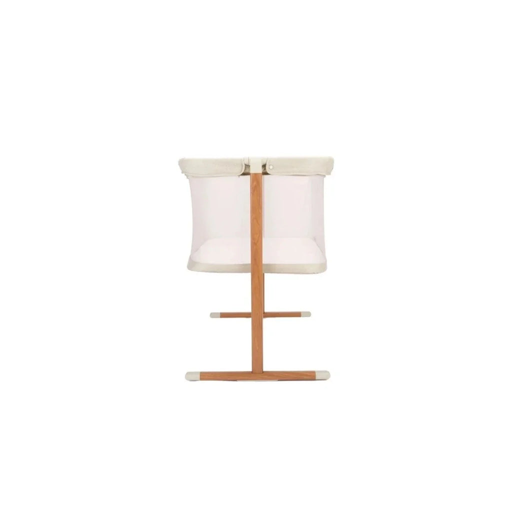 Ecru and walnut crib with mesh sides and padded fabric top rail