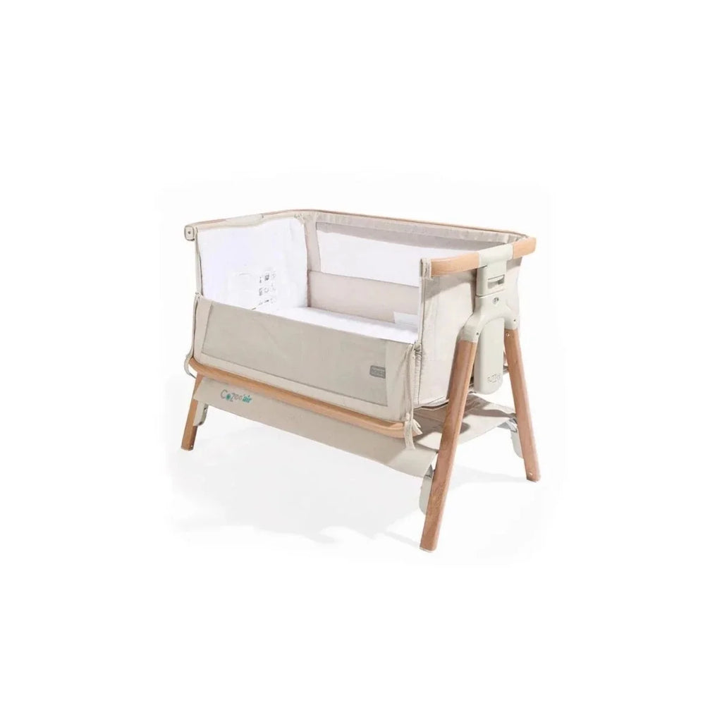 Ecru bedside crib with mesh side panels and walnut legs
