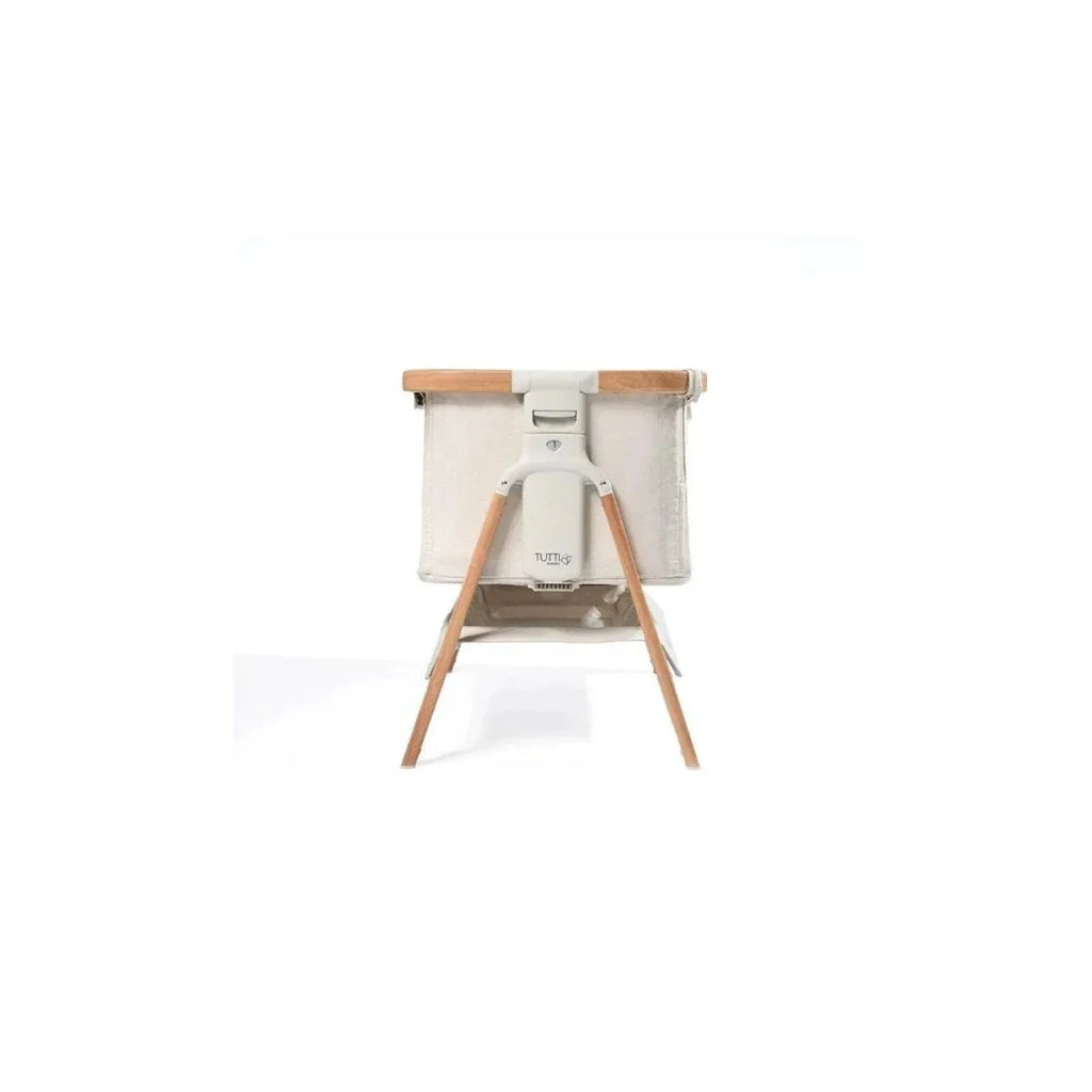 Ecru bedside crib with walnut stand and curved base supports