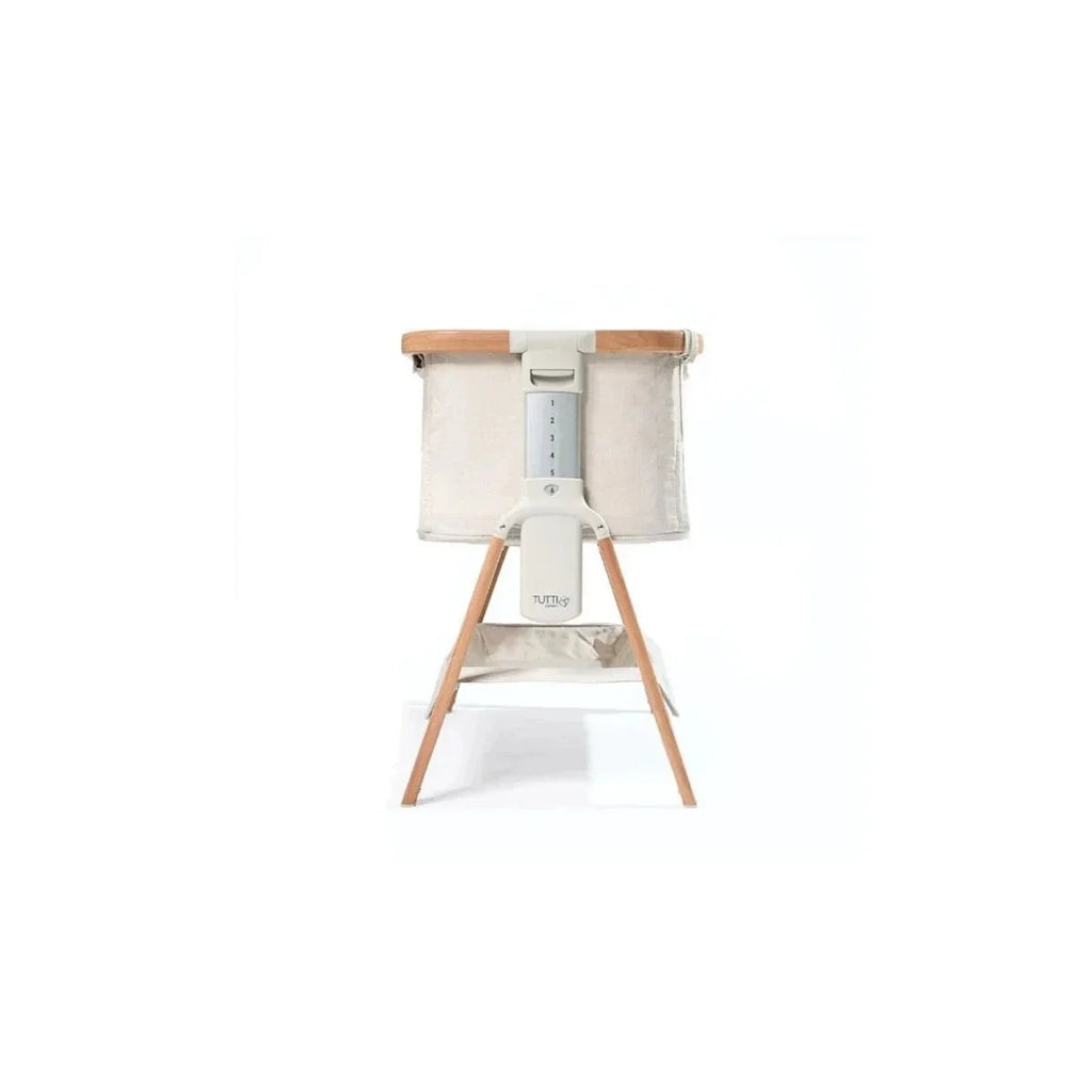 Ecru bedside crib with walnut legs and side panel view