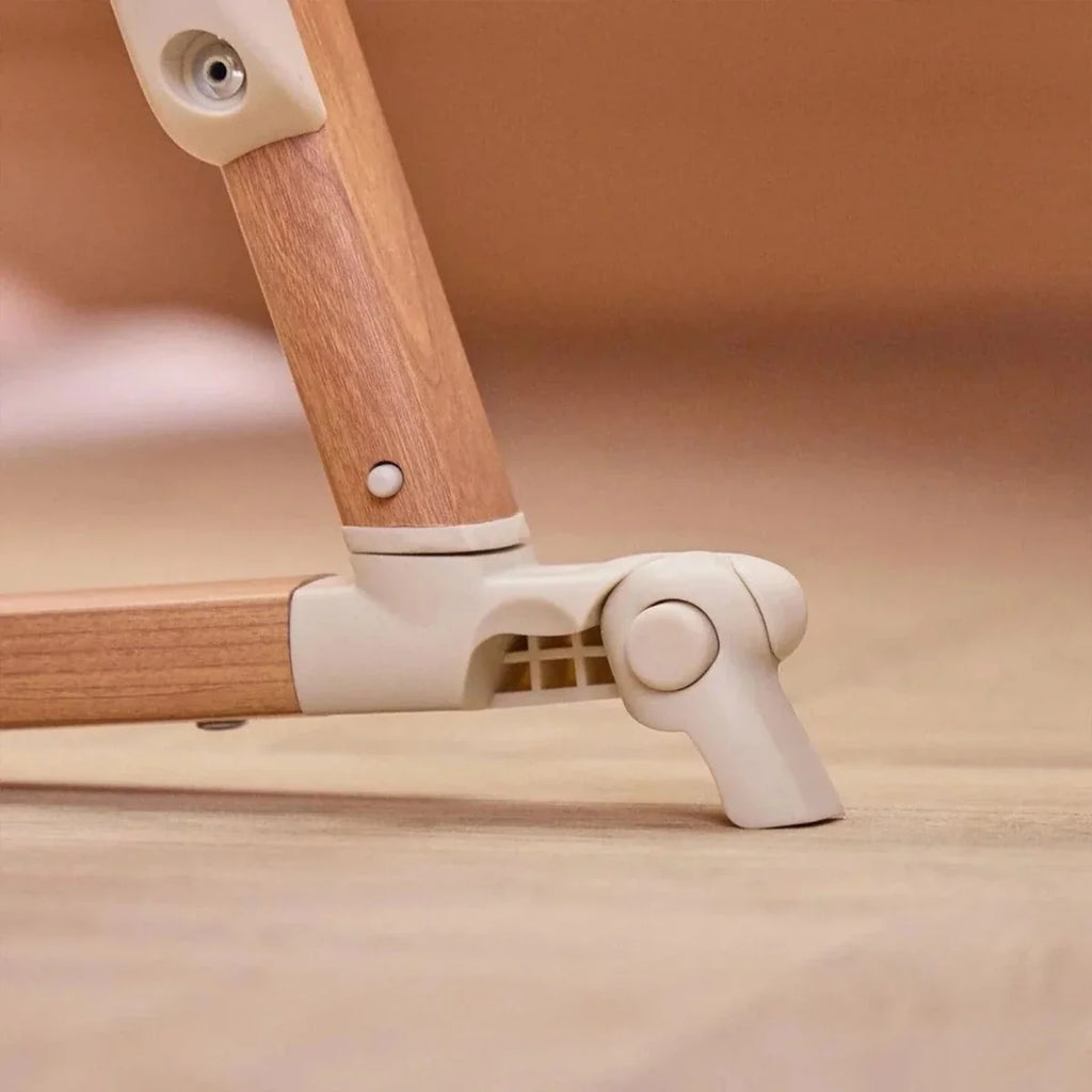 Walnut side rail and ecru foot pedal with circular control on bedside crib