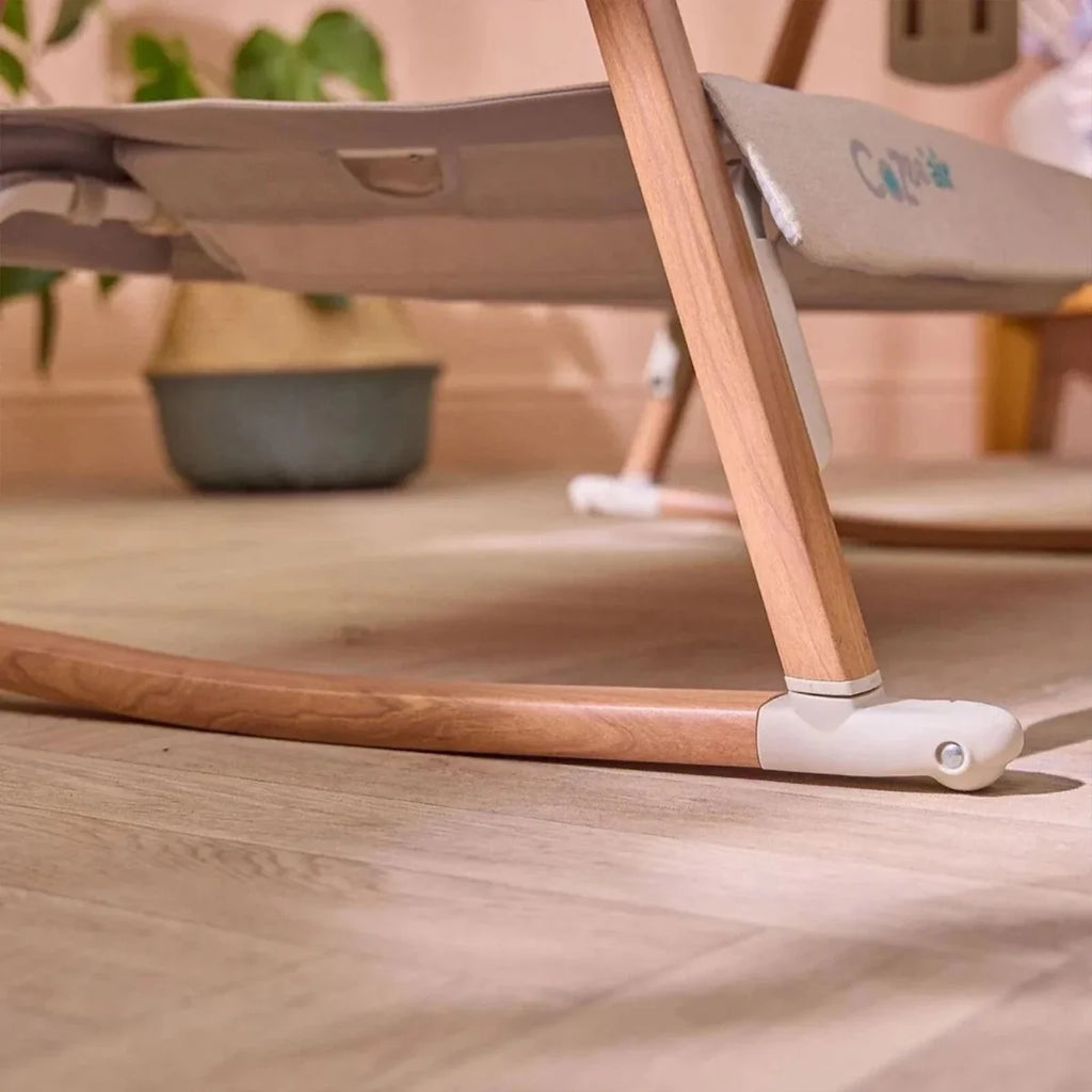 Ecru base rail and walnut legs with locking caster on bedside crib