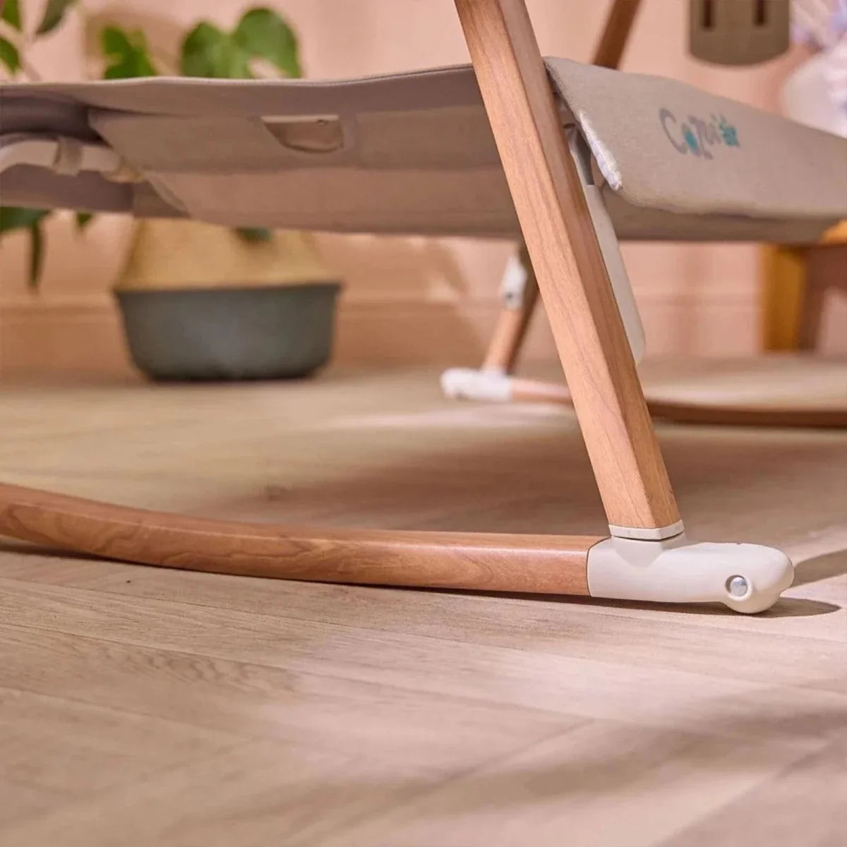 Ecru base rail and walnut legs with locking caster on bedside crib