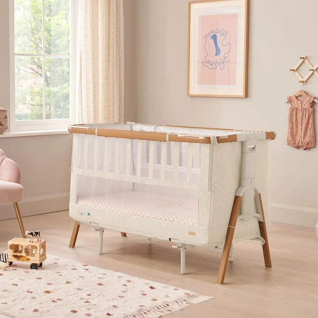 Walnut and ecru bedside crib with white mattress, mesh sides, and low open base