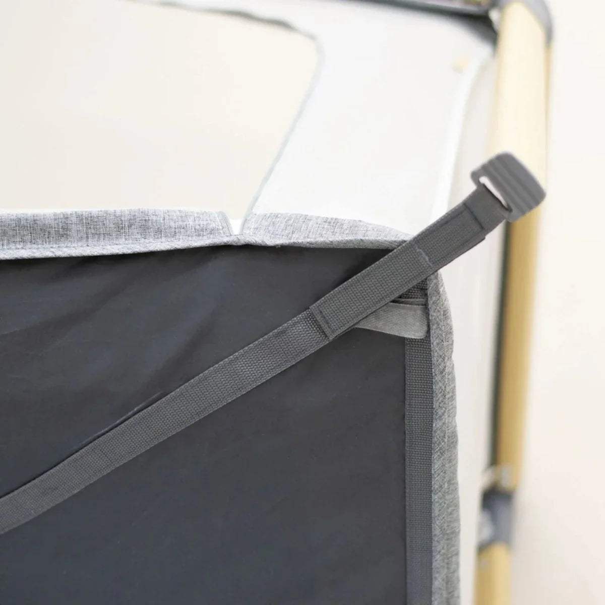 White fitted sheet secured with gray fastening straps on an angled corner.