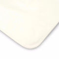 Waterproof cotton mattress protector corner, cream fabric with rounded edge.