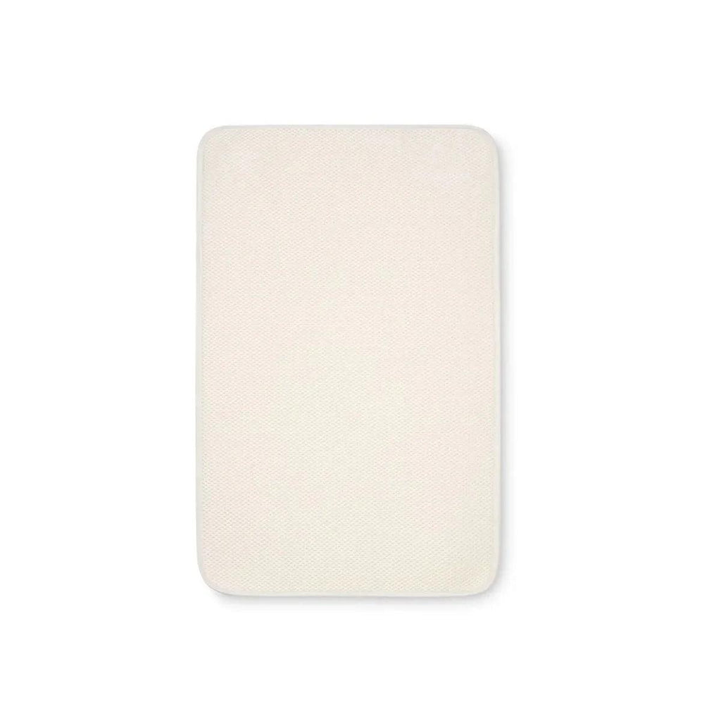 Bedside crib mattress topper protector, cream rectangular cover with rounded corners
