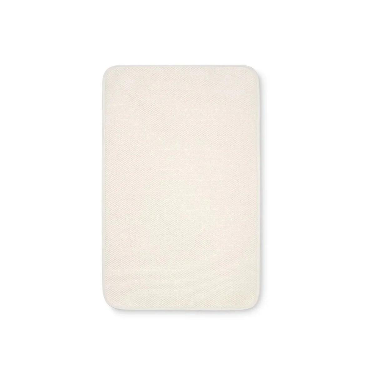 Bedside crib mattress topper protector, cream rectangular cover with rounded corners