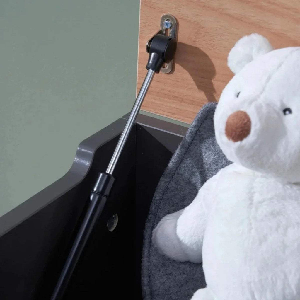 Toy box with raised lid and visible metal gas strut support