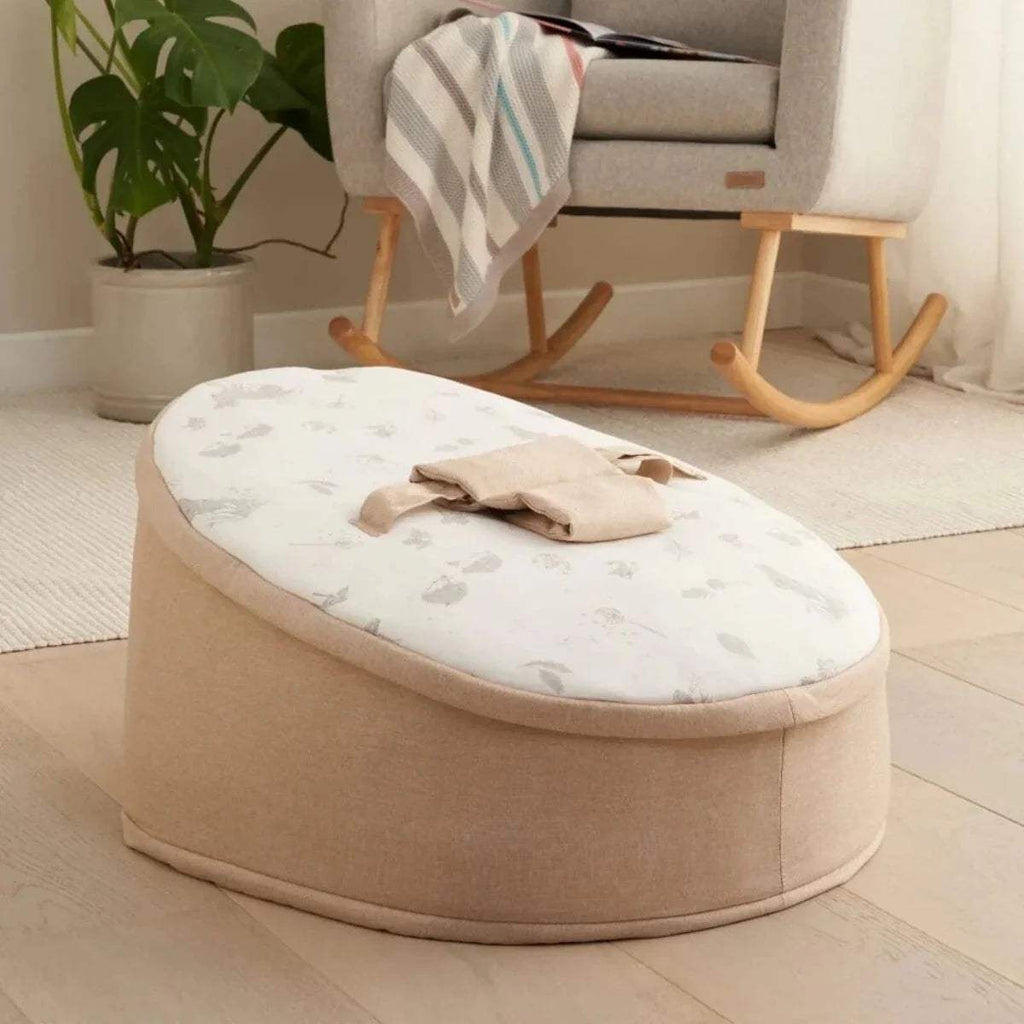 Round baby beanbag with taupe base and white animal-pattern cover, beige bow strap