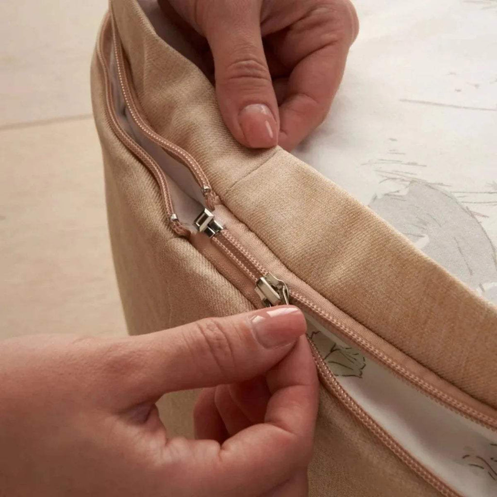 Beige beanbag zipper with metal pulls and beige fabric seam close-up