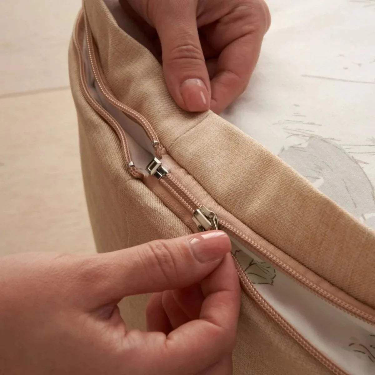 Beige beanbag zipper with metal pulls and beige fabric seam close-up