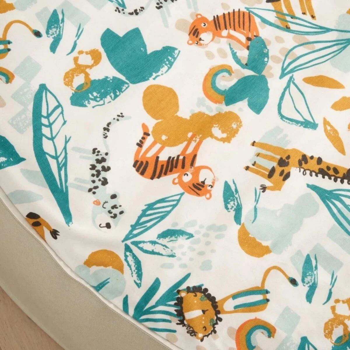 Close-up of cream fabric with teal and orange jungle animal print