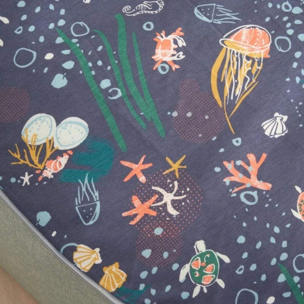 Close-up of navy ocean-pattern beanbag cover with jellyfish, fish, shells, and stars.