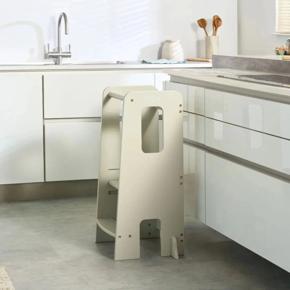 Light beige toddler learning tower with side cutout handle openings and two steps