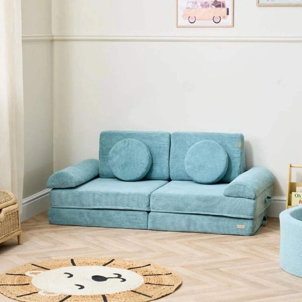 Kids play sofa with rounded armrests and two teal bolster cushions