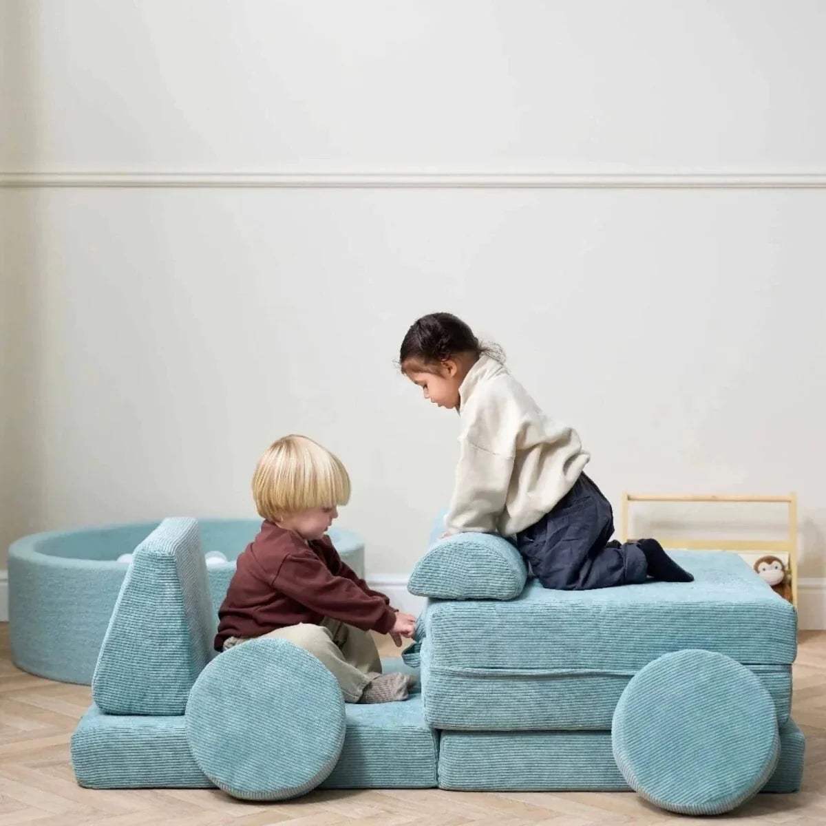 Kids play sofa with children on the seat and round front cushions, teal fabric