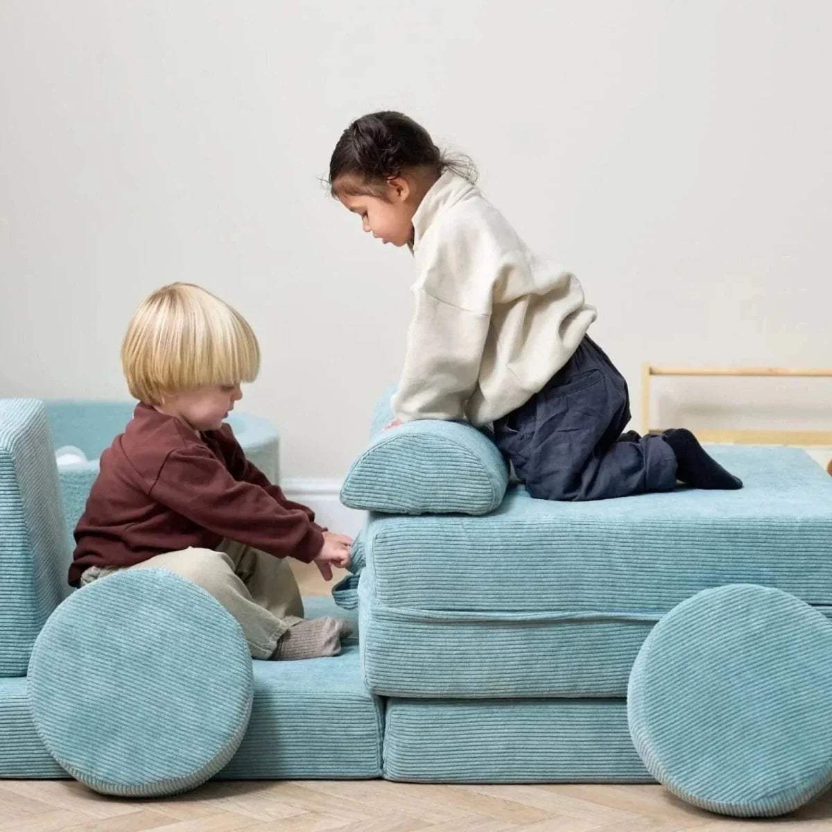 Kids play sofa in ocean stone blue with rounded arms and circular floor cushions, fabric cover