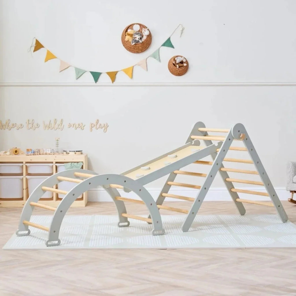 Montessori pikler climbing frame with gray supports and wooden rungs plus climbing wall