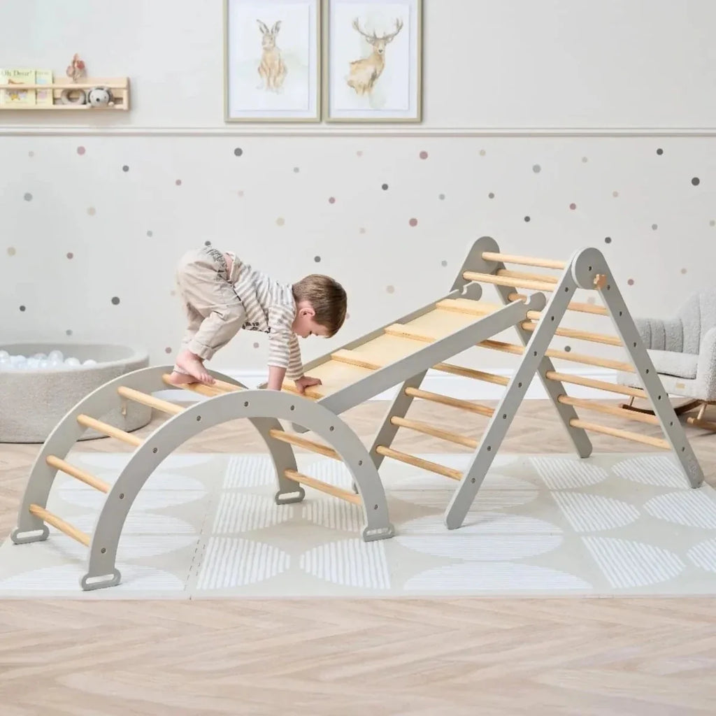 Montessori pikler climbing frame with gray arch base and wooden ladder, set up for play