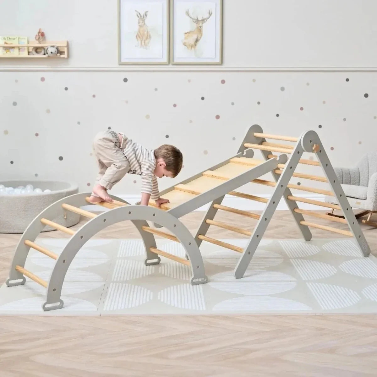 Montessori pikler climbing frame with gray arch base and wooden ladder, set up for play