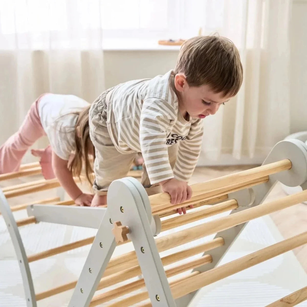 Pikler climbing frame with light wood rails, grey posts, and angled ladder rungs