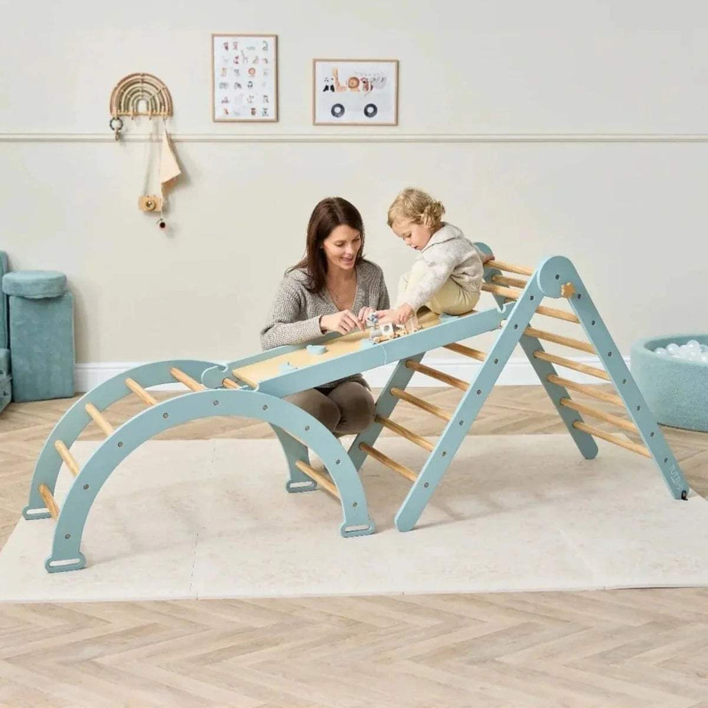 Pikler climbing frame with wooden rungs and ocean stone climbing wall, child playing