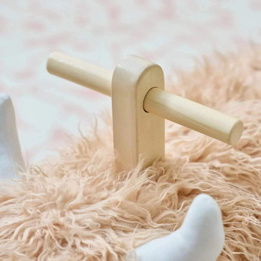 Highland cow rocking toy close-up of wooden rocker base and handles.