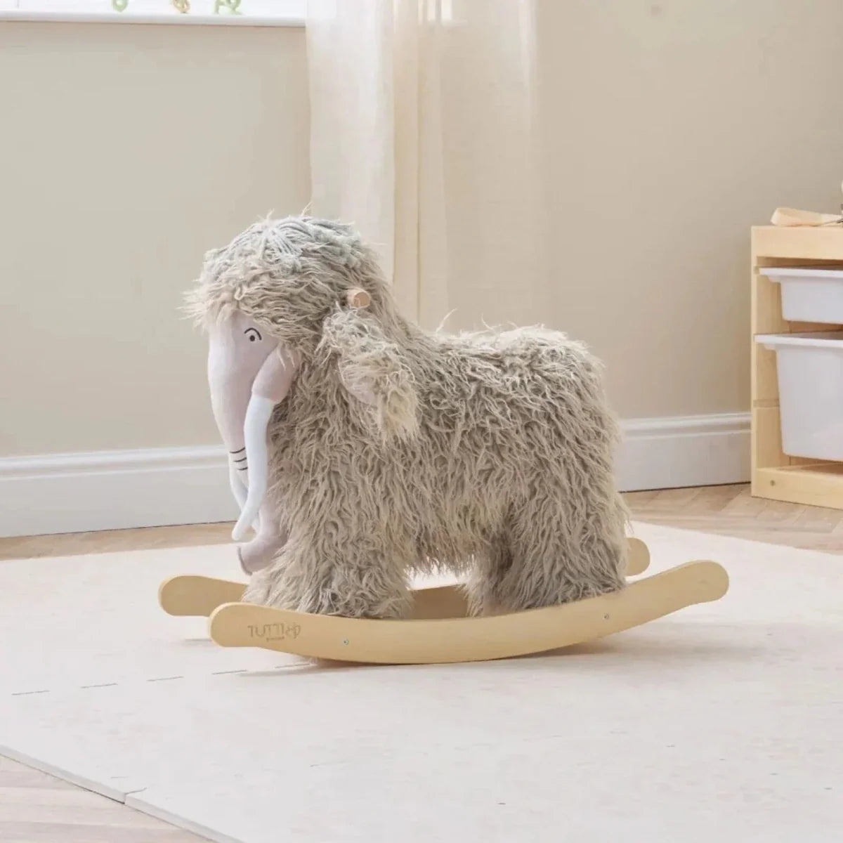 Gray plush woolly mammoth rocking toy with curved wooden base.