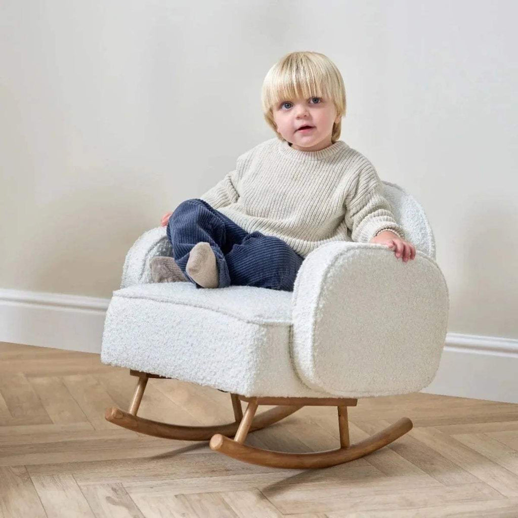 Kids rocking chair in cream teddy fabric with a child seated inside