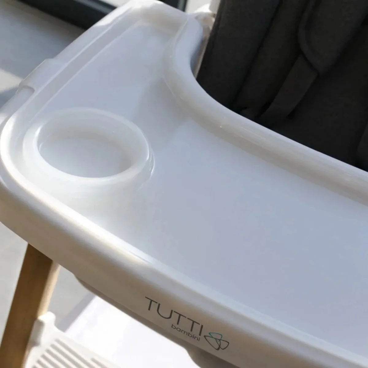 White highchair tray with cup holder and TUTTI branding