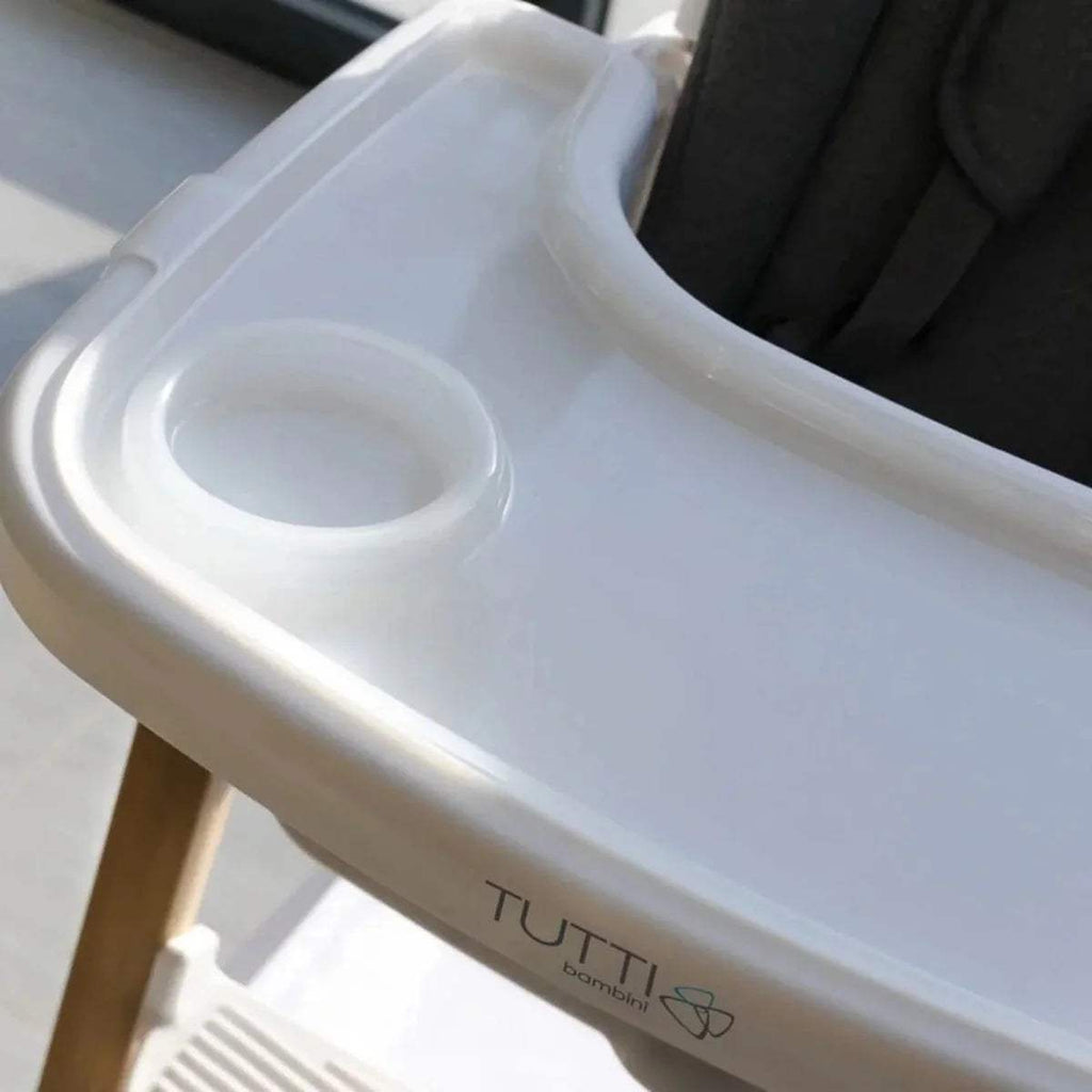 White highchair tray with built-in cup holder and TUTTI logo on front