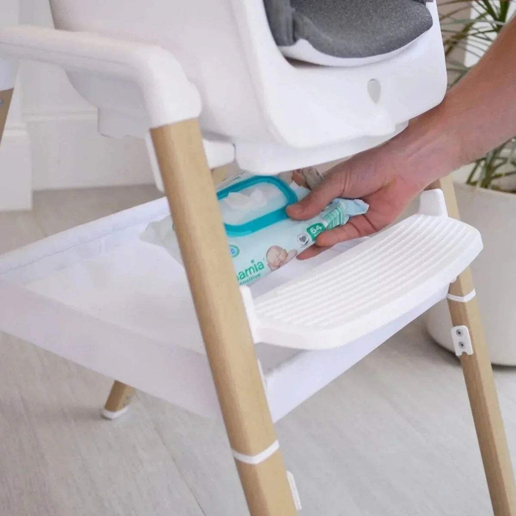 White high chair with lower shelf holding a baby wipe pack