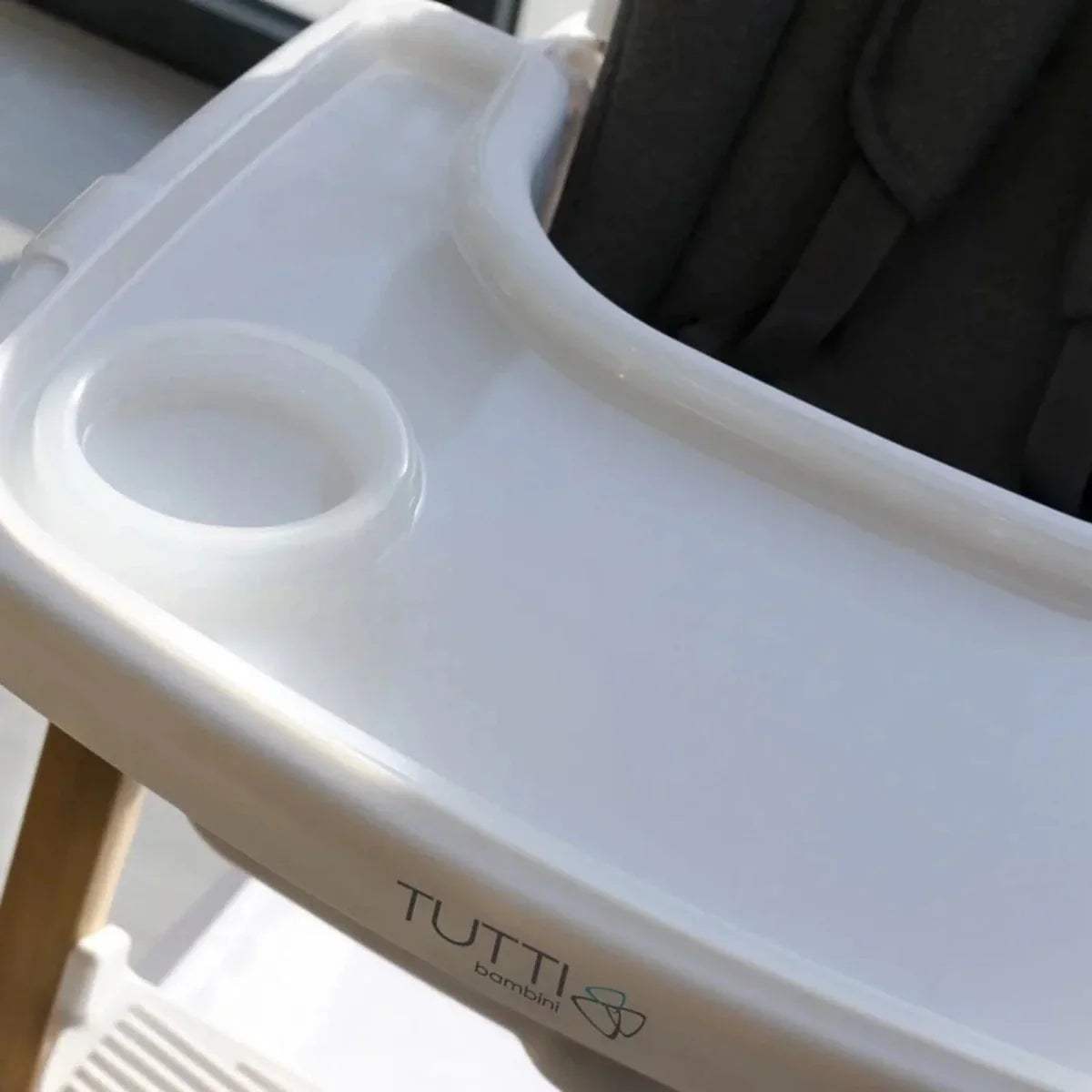 White highchair tray with cup holder and raised edges, close-up