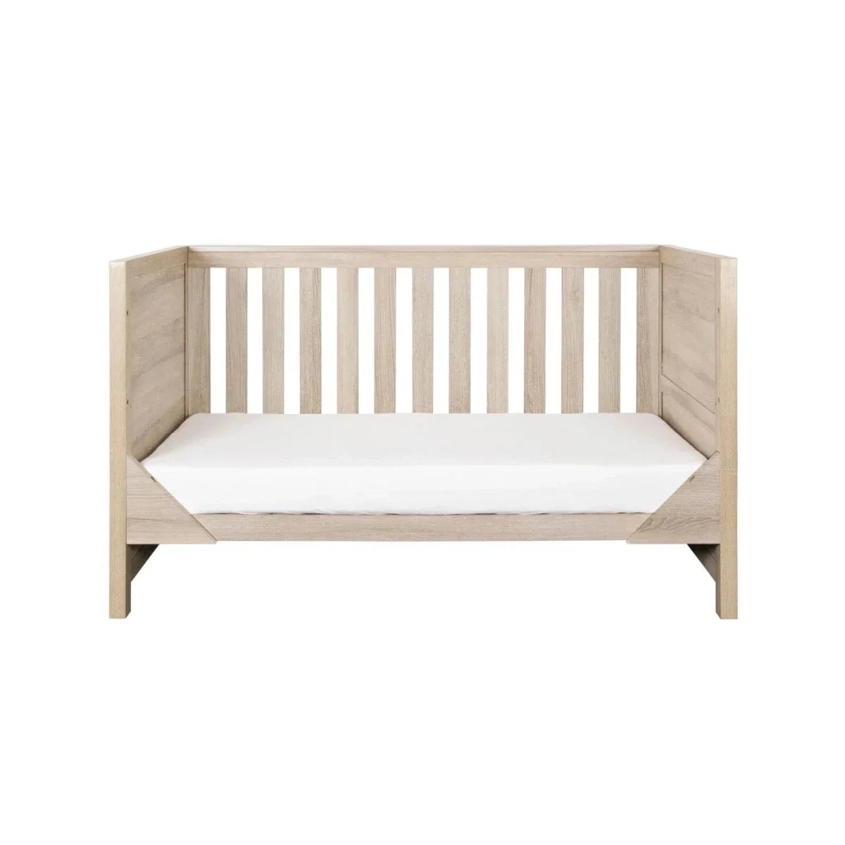 Light oak toddler bed with vertical slat guardrails and white mattress
