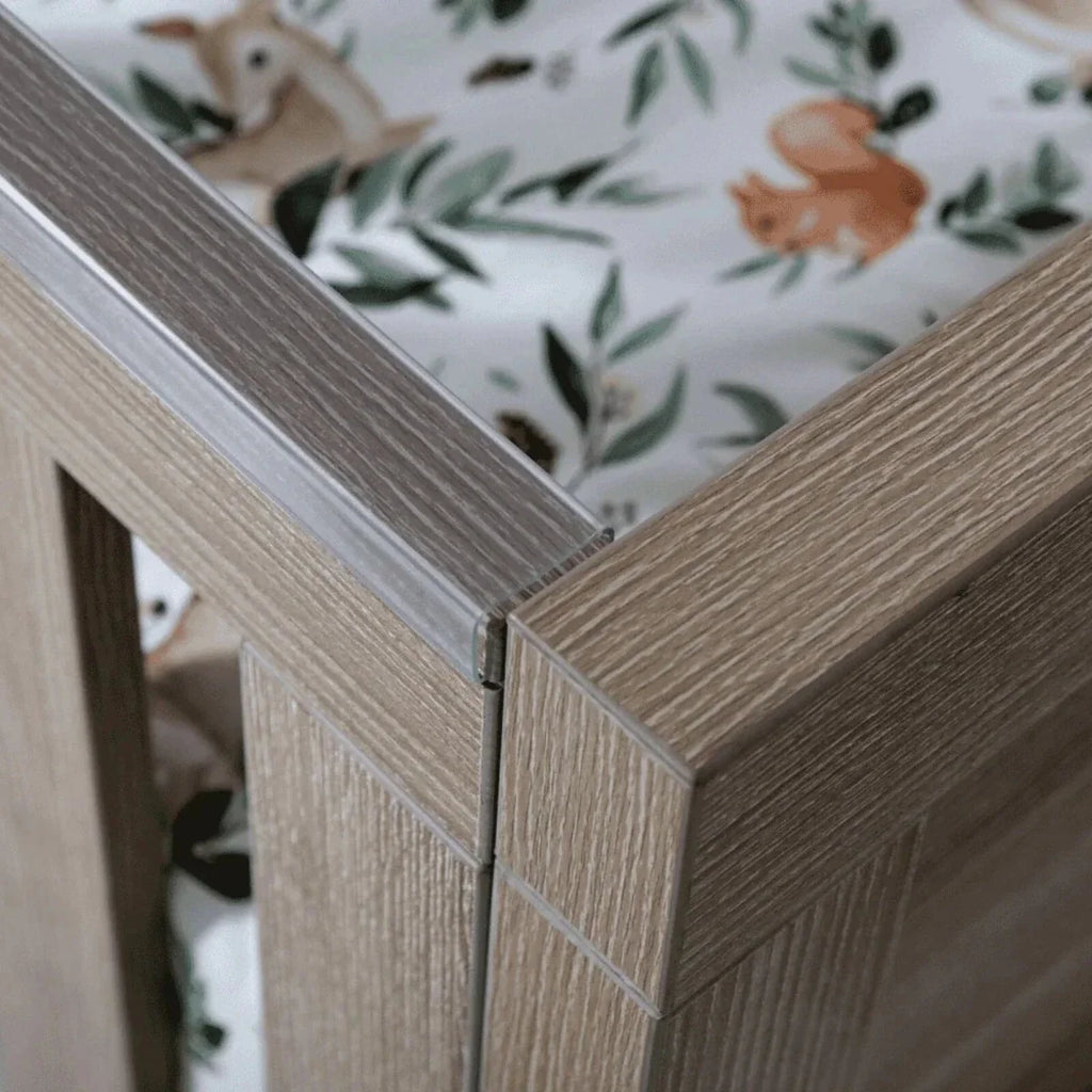 Light oak bed frame corner with joined panels and protective side trim