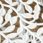 Close-up of white ornate chair lattice cutouts with leaf-shaped scrollwork