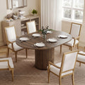 Dark walnut round dining table with pedestal base and dining chairs around the top