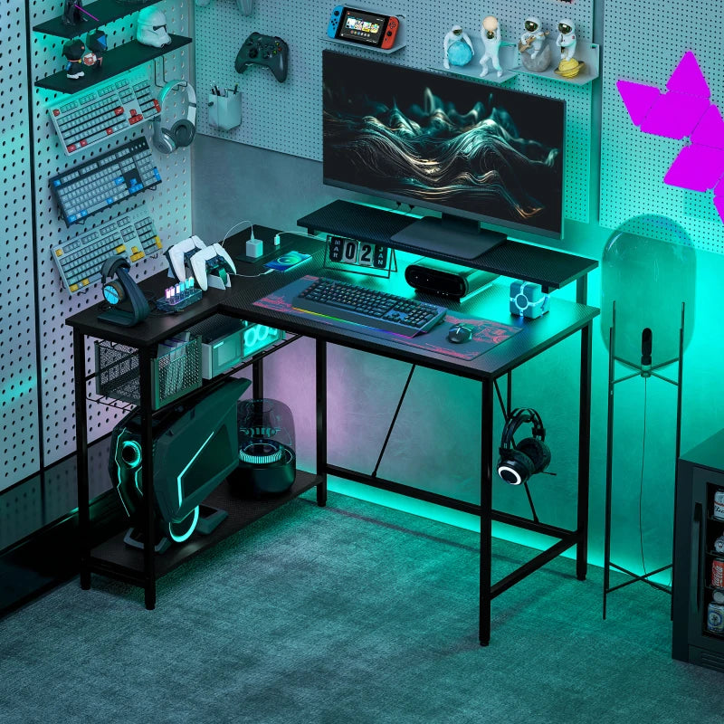 Black L-shaped gaming desk with integrated LED lighting and lower storage shelf